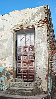 Street view of an old building facade with metal door, Latacunga, Ecuador