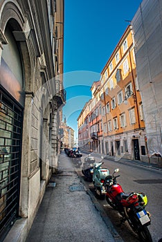 Street View With Old Buildings And Motorcycles in Trieste, Italy