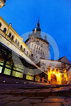 Street view of the old Clock Tower monument building `Turnul cu ceas` in SighiÃâ¢oara, Romania photo