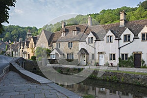 Street view of old riverside cottages in the picturesque Castle Combe Village, Cotswolds, Wiltshire, England - UK