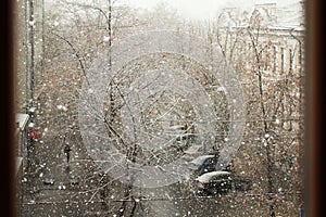 Street view from the room on a dull cloudy winter day. The first snow falls on the street