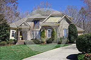 Street-view of a suburban house with stone exterior in an affluent neighborhood