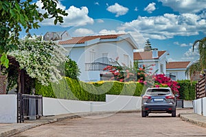 Street view with white houses, green bushes and blue sky in Cyprus photo