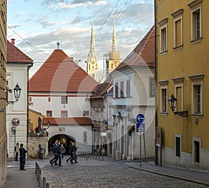 A street view in Zagreb`s upper town with historic stone gate and Cathedral towers on background, Croatia