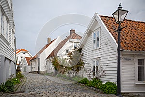 Street with white painted wooden houses in the old part of Stavanger