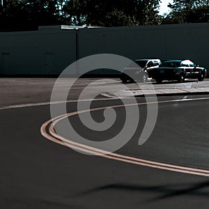 A Street winding and turning against 2 parked cars