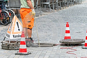 Street works on sewer channel with warn sign in german words for channel works