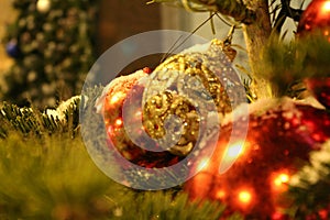 Christmas decorations on the christmas tree in red and gold colors in the form of balls close-up.On the street or in the yard