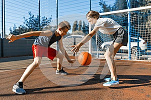 Streetball basketball game with two players, teenagers girl and boy with ball, outdoor city basketball court