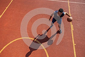 Streetball player guy training basketball at outdoor court.