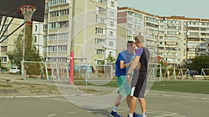 Streetball player helping fallen opponent to stand up