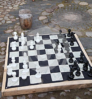 Streetchess pieces at a square. Board of a chess game. A peaceful scene of an outdoor chess match in a park.