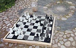 Streetchess pieces at a square. Board of a chess game. A peaceful scene of an outdoor chess match in a park.