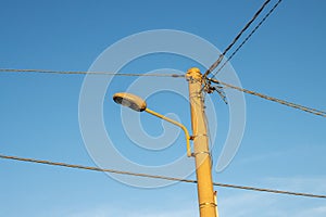 Streetlamp with cables and bright blue sky, Italy