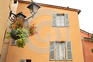 Streetlamp flowers and opened jalousies