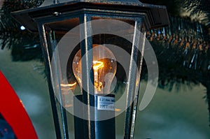 Streetlight lantern. Lantern for street. Lantern with light on. Streetlamp bulb
