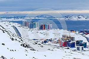 Streets and building blocks of greenlandic capital Nuuk city at the fjord, view from snow hills, Greenland photo