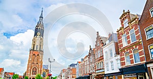 Nieuwe Kerk tower and traditional houses on Market square of old beautiful city Delft, Netherlands