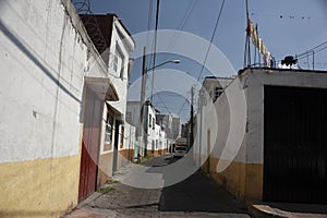Streets of a picturesque rustic cobbled avenues village surrounding the exterior facades painted bicolor in yellow and white Mexic