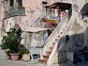 Streetview of a facade with stairs and a boat in the harbor of P