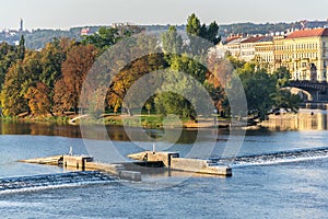 Strelecky Island with weir on Vltava river near National Theatre and the Charles Bridge, Prague, Czech Republic, sunny day photo