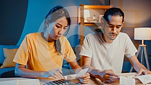 Stress asia couple man and woman use calculator for calculate family budget, debts, expenses during financial economic crisis at