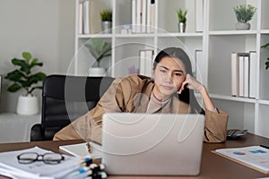 Stress Asian businesswoman having a serious with her business while working in the office