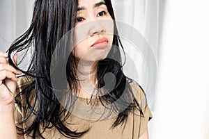 Asian woman have problems with oily hair and thinning hair looking at the mirro photo
