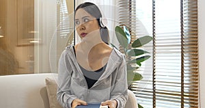 stress asian woman use headphones listen to music reading book