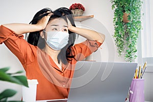 stress Asian worker woman wearing protective mask angry and get depressed during covid-19 lockdown bored with self-quarantine