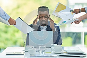 Stress, business and black man on laptop multitasking with documents, paperwork and team projects. Corporate boss