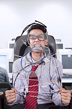 Stress businessman tied in rope at office