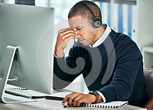 Stress, call center and a man with a headset at computer for customer service problem. African person consultant at pc