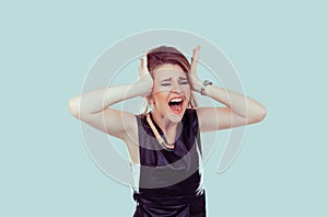 Stress. Closeup portrait stressed woman covers ears with hands yelling screaming with temper tantrum isolated green background.