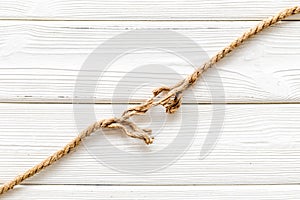 Stress concept with breaking rope on white wooden background top view mockup