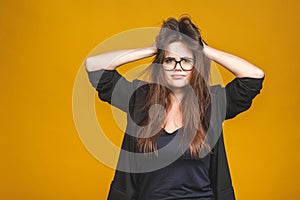 Stress concept. A very frustrated and angry business woman pulling her hair. Isolated against yellow