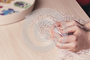 Stress concept. Woman`s hands popping bubbles from a bubble paper photo