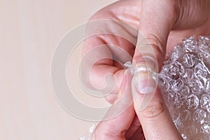Stress concept. Woman`s hands popping bubbles from a bubble paper photo