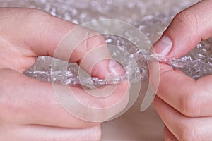 Stress concept. Woman`s hands popping bubbles from a bubble paper photo