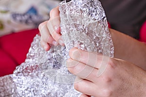 Stress concept. Woman`s hands popping bubbles from a bubble paper photo