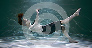 Stress disorder. Young business woman sinks under water with smart phone in hand slow motion. Information overload.