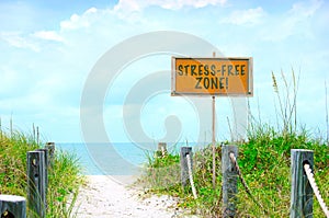 STRESS-FREE ZONE sign at beautiful beach path to ocean