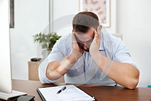 Stress, headache and business man in office with documents for burnout, mental health risk or depression. Depressed