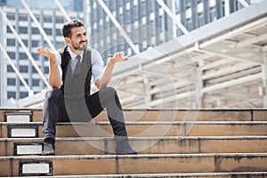 The stress man sitting alone on the stair outdoor. Young business man crying abandoned lost in depression with mobile phone