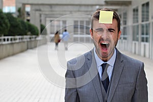 Stress out businessman with a note on his forehead
