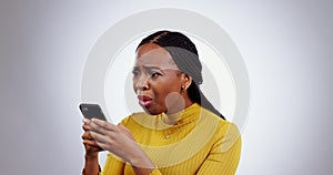 Stress, phone and face of black woman in studio with wtf, fake news or why on grey background. Smartphone, anxiety and