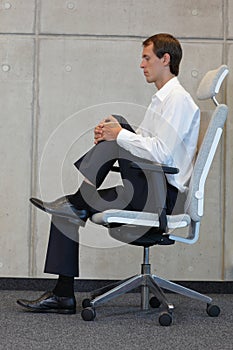 Stress reduction in office work - man exercising on chair