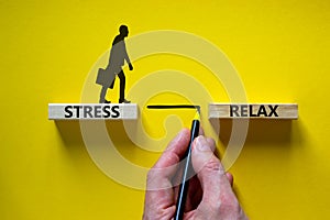 Stress or relax symbol. Wooden blocks with words `Stress, Relax`. Yellow background. Businessman hand, businessman icon.