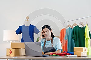 Stress serious asian woman doing clothing business selling online. she using laptop computer. online sell marketing