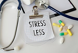 Stress Less text on card in doctor\'s office on desktop background, medical concept